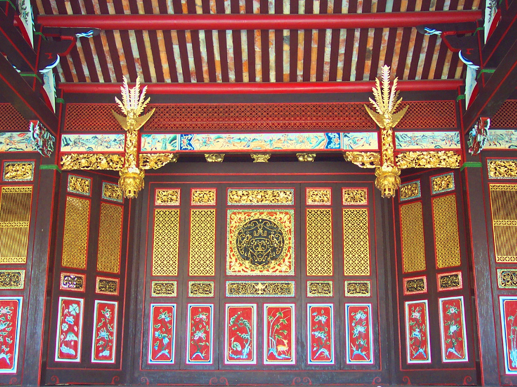 Gold trimmed wooden shutters covering the back of an open stage.