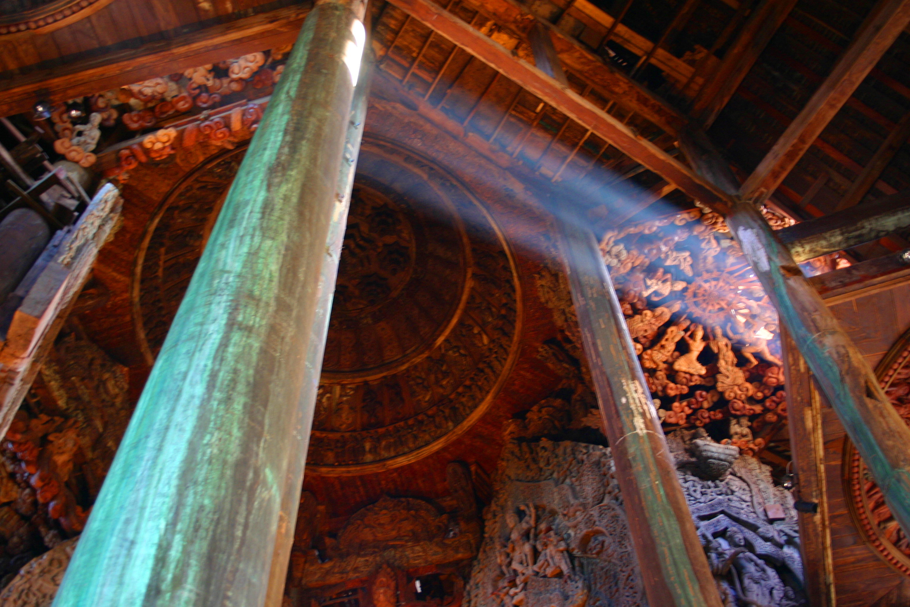 A shaft of sunlight streaks across an intricately carved wooden ceiling